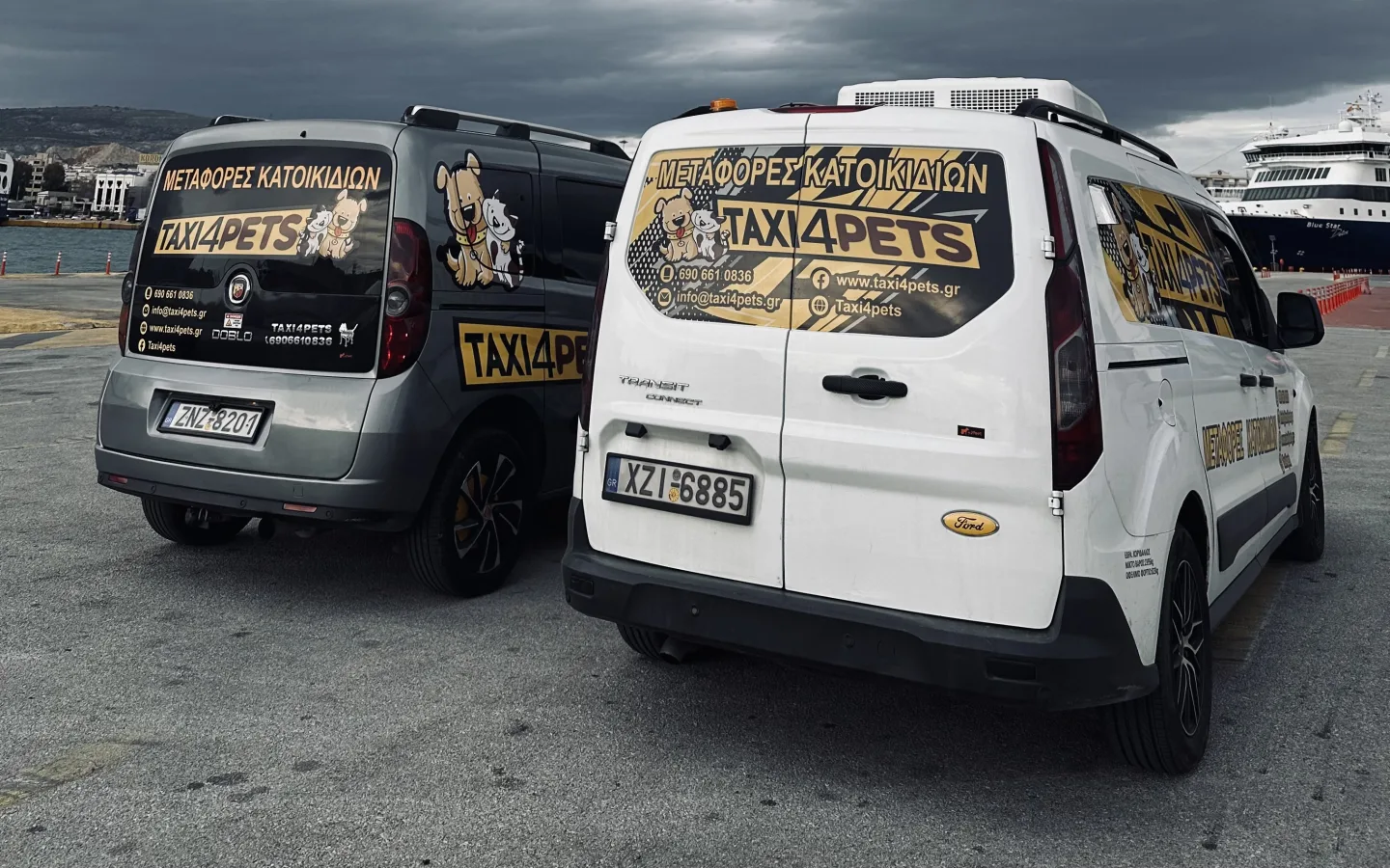 Τα δύο οχήματα του Taxi4Pets σταθμευμένα στο λιμάνι, με πλοίο δεμένο στο βάθος